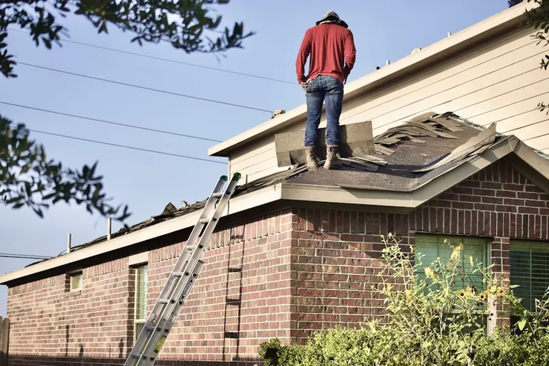 Professional roofer working on a residential roof in Frances
